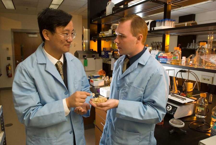 Percival Zhang (left) works with a student in a biological systems engineering research laboratory.
