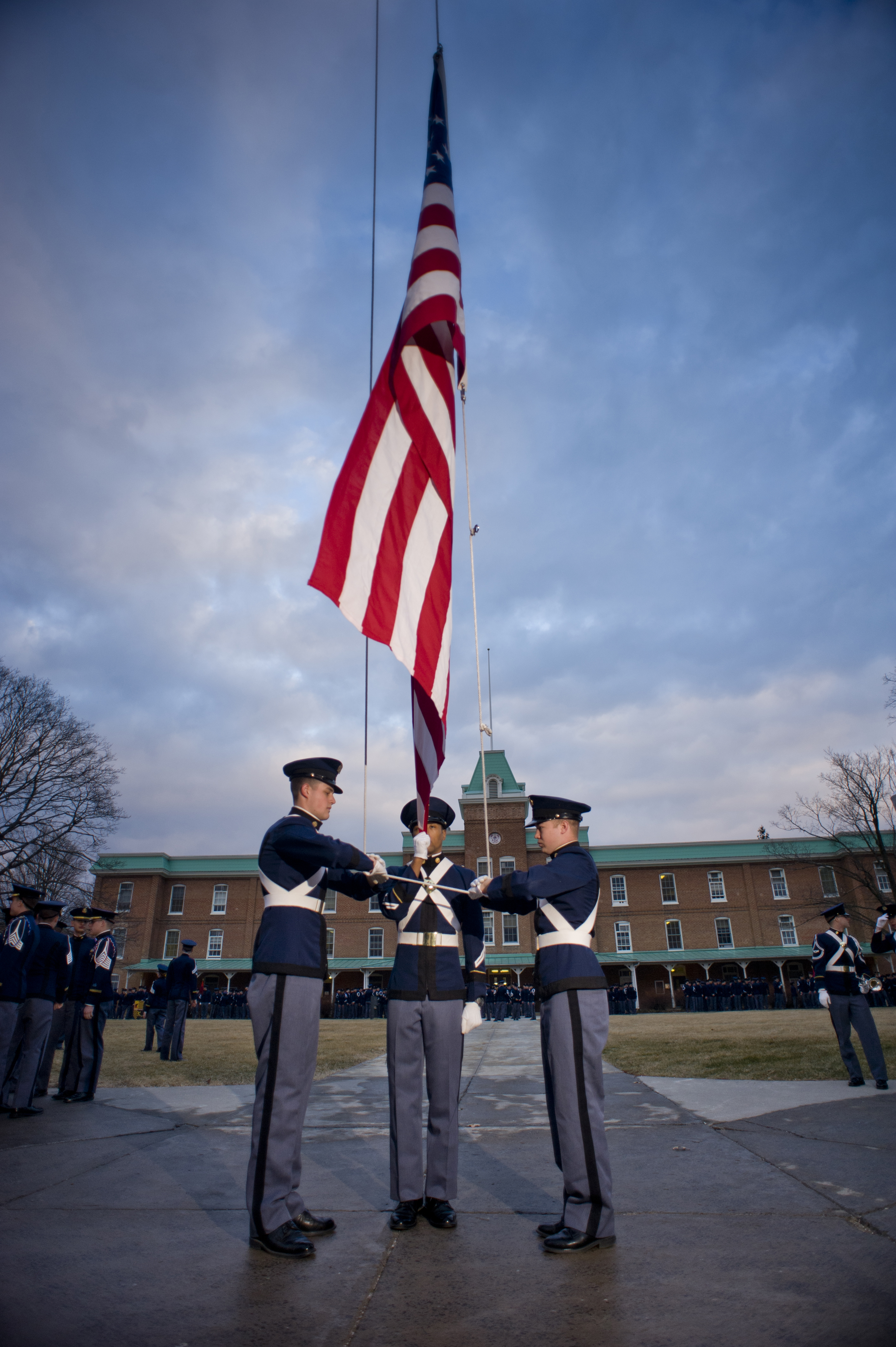 Members of the Virginia Tech Corps of Cadets raise the United States flag in front of Lane Hall.