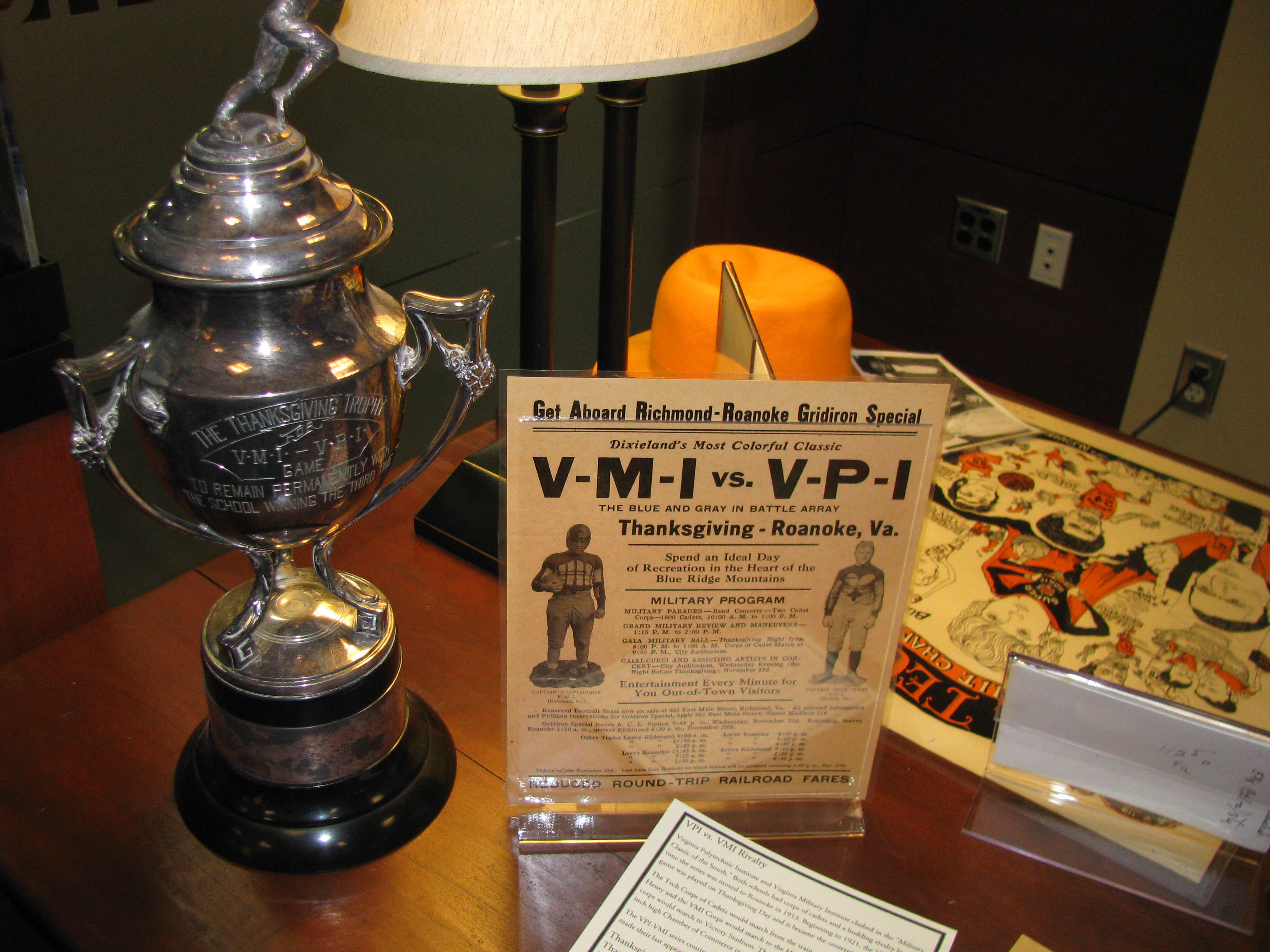 Photograph of a trophy, poster and other items from a Virginia Tech football game against the Virginia Military Institute. 