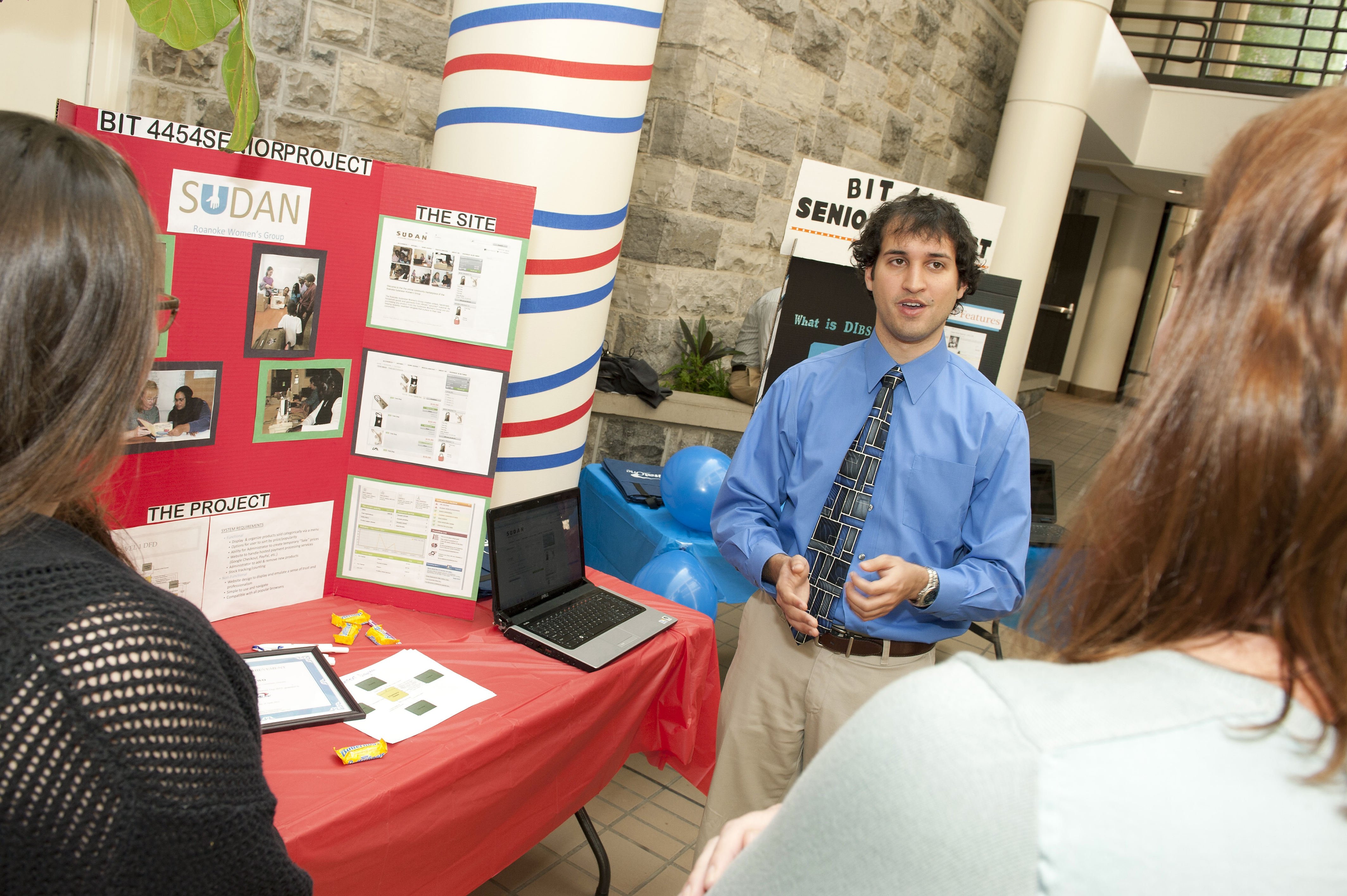 Pamplin student Elon Daghigh describes his team's senior class project to a visitor.