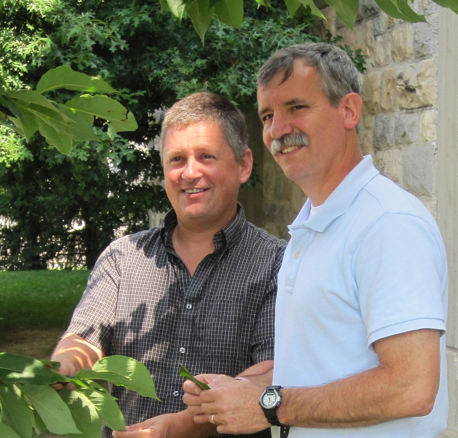 John Peterson and John Seiler standing near a tree.