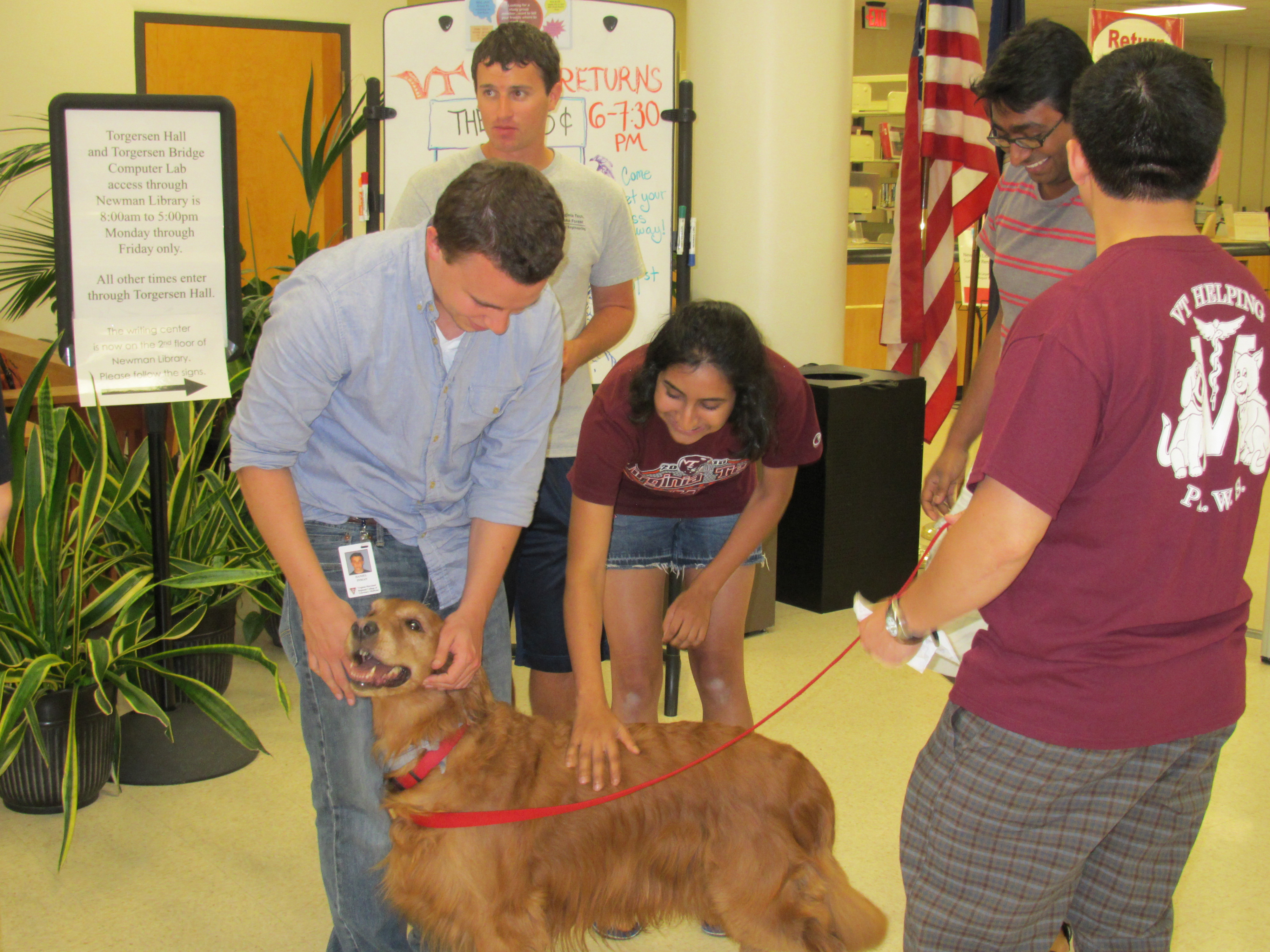 Virginia Tech students pet therapy dogs at the library.