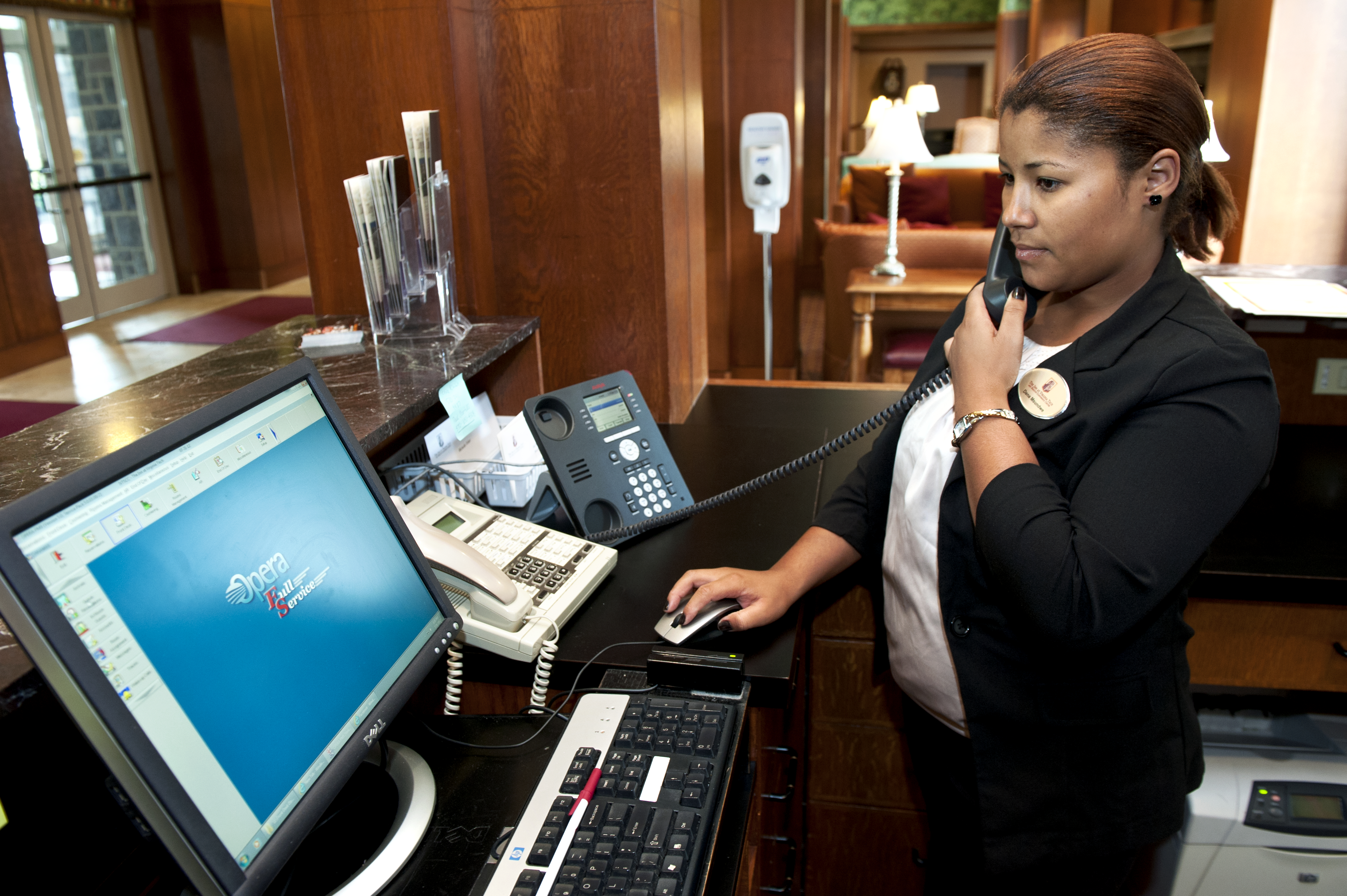 A hotel front desk clerk uses one of the new phones installed as part of the unified communications switchover
