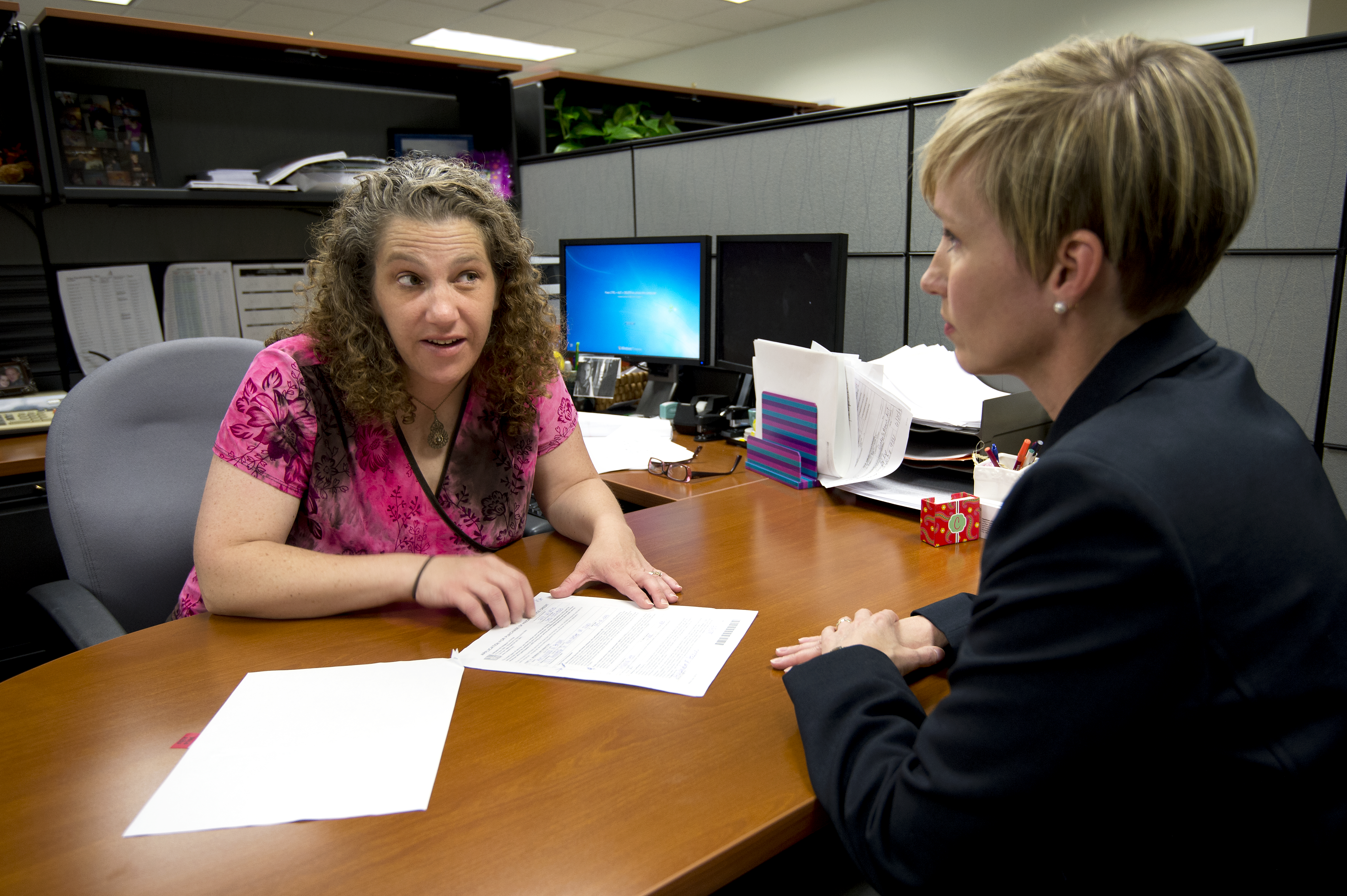 Human Resources Assistant Caroline talks with a colleague. 