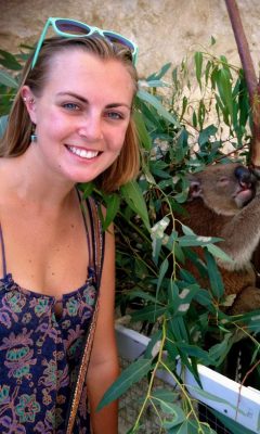 Paige McKinley next to a koala in a tree.
