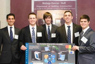 The five students on the third place team stand with their presentation board.