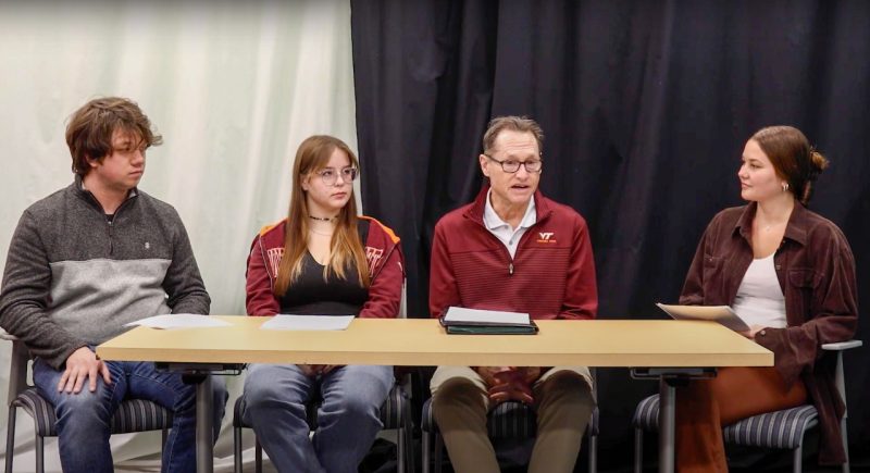 Students sitting at a table interviewing a Virginia Tech Athletics psychologist for a podcast.