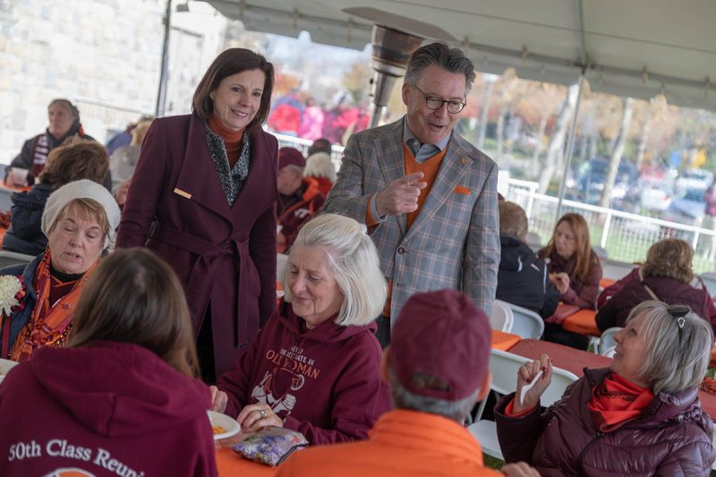 President Tim Sands and Dr. Laura Sands talk with alumni at the Homecoming Tailgate.